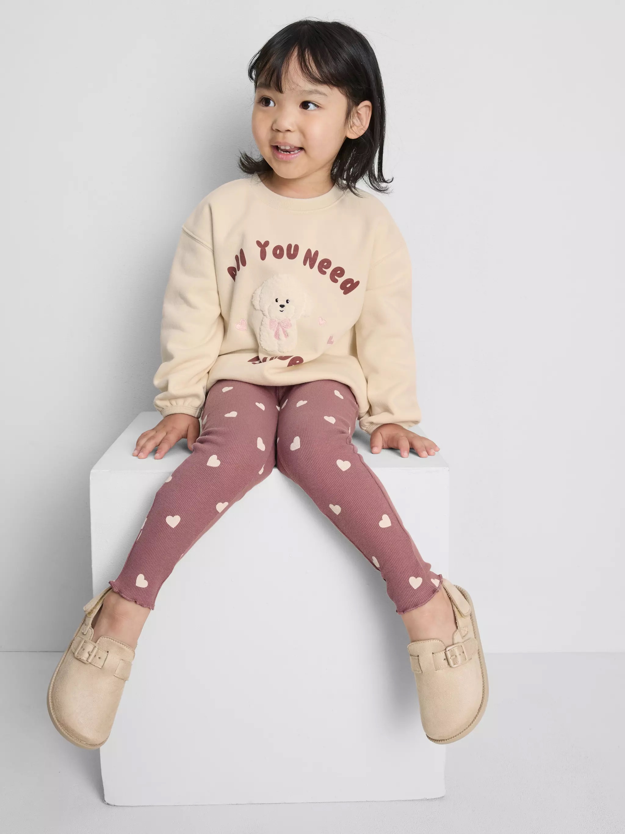 Girl wearing a hoodie and leggings.