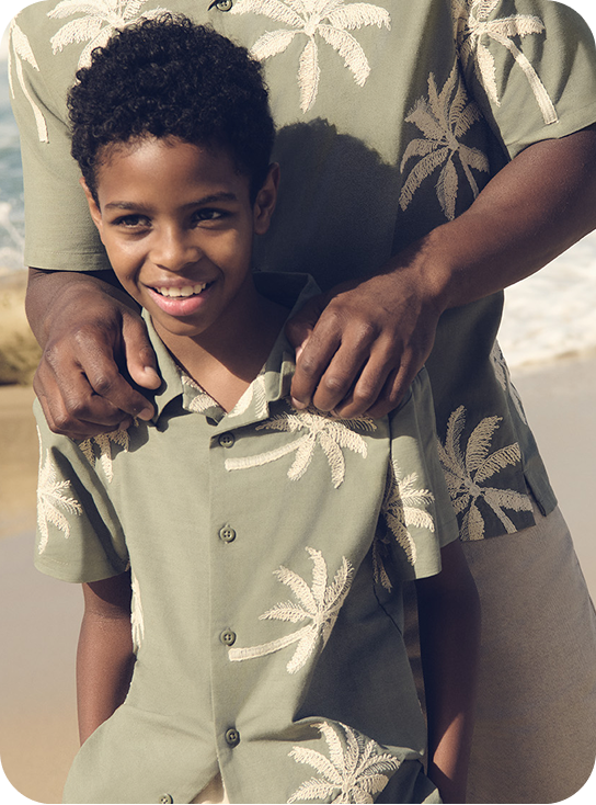 Young boy wearing a palm tree green shirt 